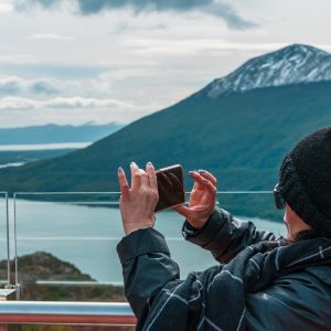 Una turista saca una foto con su celular al Lago Escondido desde el Mirador Paso Garibaldi en Ushuaia.