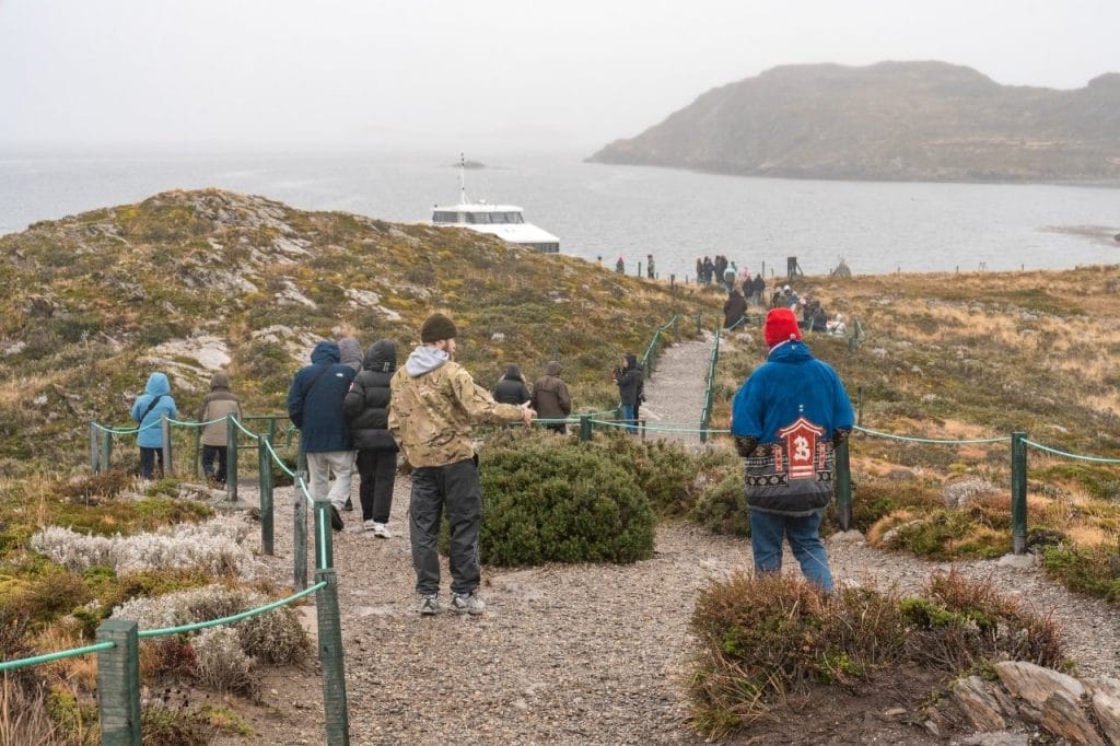 Turistas recorriendo los senderos naturales de las Islas Bridges en el Canal Beagle, Ushuaia.