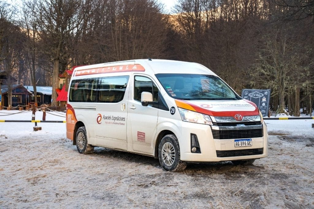 Combi de transporte turístico de Aswalek Expediciones estacionada en la entrada nevada de Park Austral.