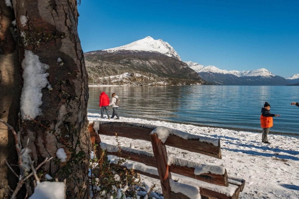 Pasajeros caminando por la orilla nevada del Lago Roca en el Parque Nacional Tierra del Fuego, Ushuaia.
