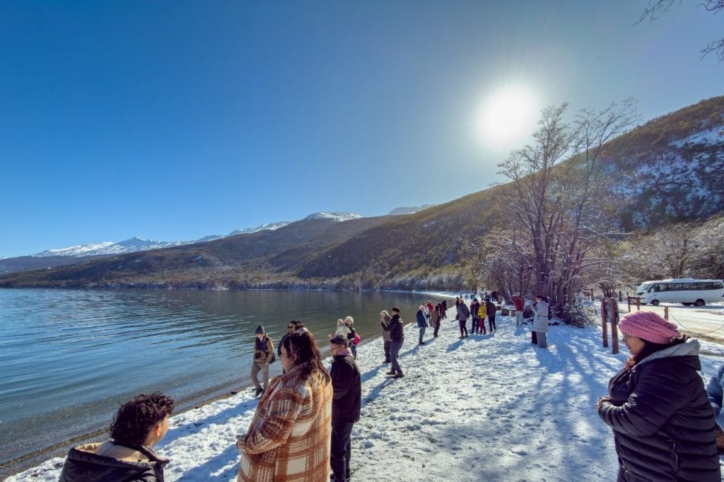 Grupo de pasajeros recorriendo la orilla nevada del Lago Roca en el Parque Nacional Tierra del Fuego, Ushuaia.