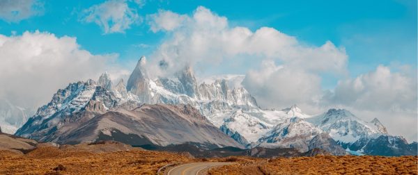 Vista del imponente Monte Fitz Roy con sus picos nevados bajo un cielo azul en El Chaltén.