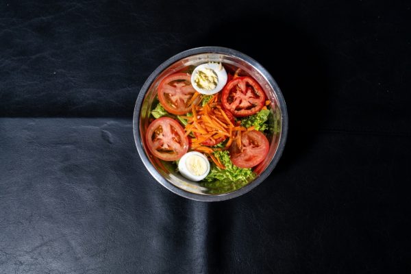 Bowl de ensalada fresca con tomate, zanahoria rallada, lechuga y huevo duro en Ushuaia.