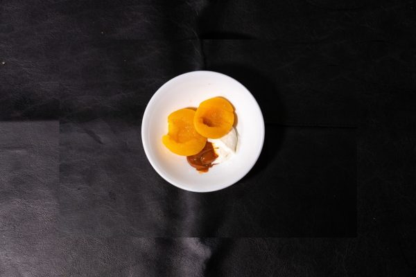 Postre de duraznos en almíbar con dulce de leche y crema servido en el refugio de Río Tristen, Ushuaia.