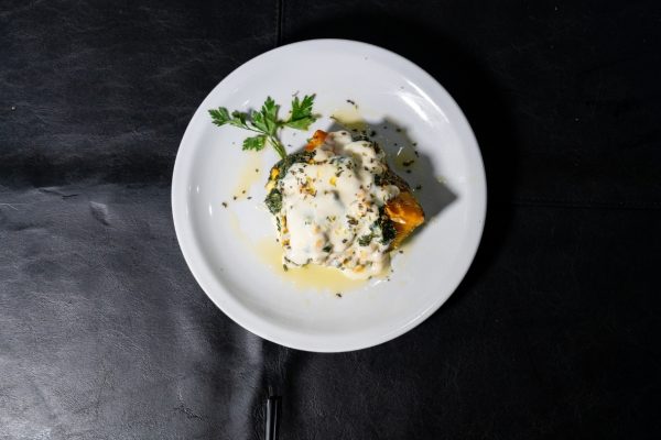 Plato de calabaza rellena con queso y vegetales junto a una porción de tarta rústica en el refugio de Río Tristen, Ushuaia.