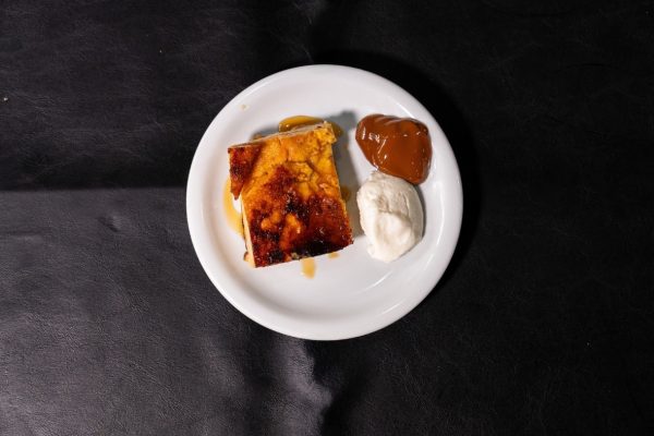 Porción de budín de pan casero con dulce de leche y crema en un refugio sobre la Ruta 3.