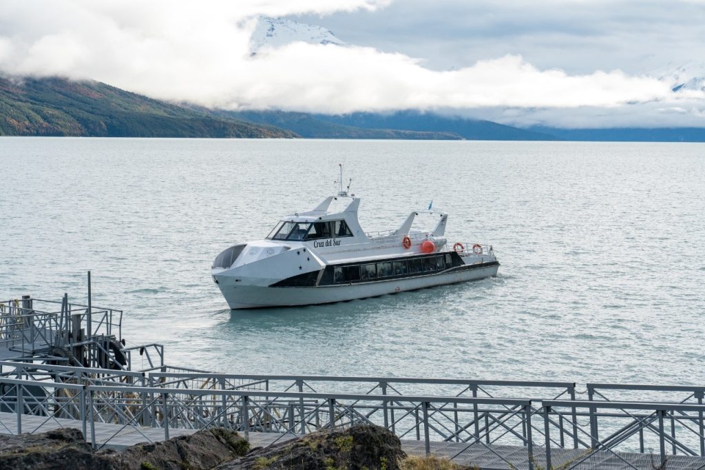 Embarcación turística Cruz del Sur navegando sobre las aguas del Lago Argentino cerca de las pasarelas del Parque Nacional.