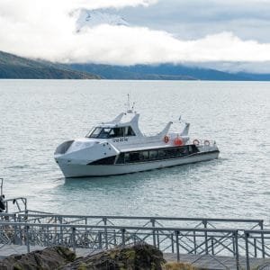 Embarcación turística Cruz del Sur navegando sobre las aguas del Lago Argentino cerca de las pasarelas del Parque Nacional.